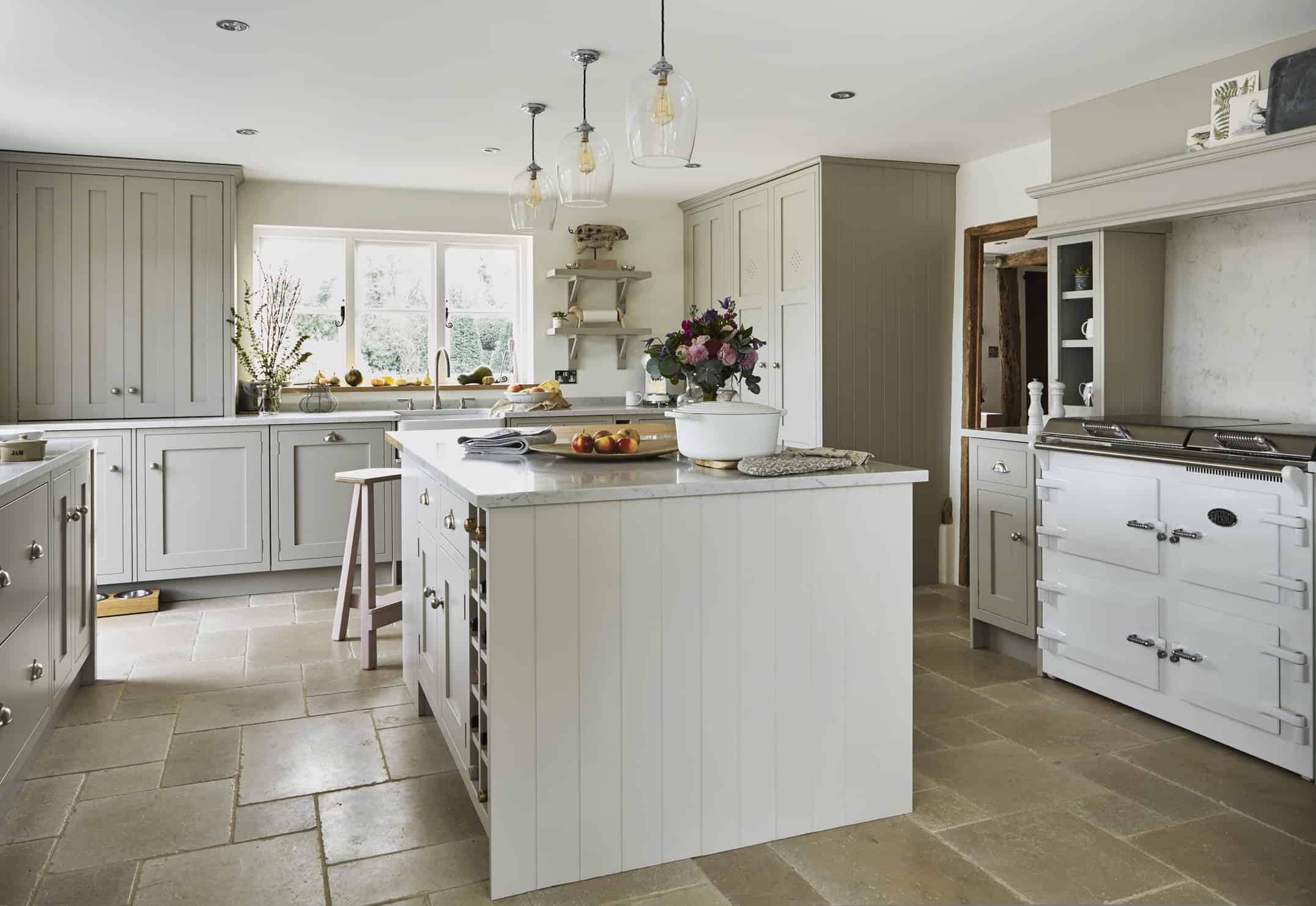 John Lewis of Hungerford shaker kitchen with white kitchen island and stone flooring and marble worktop