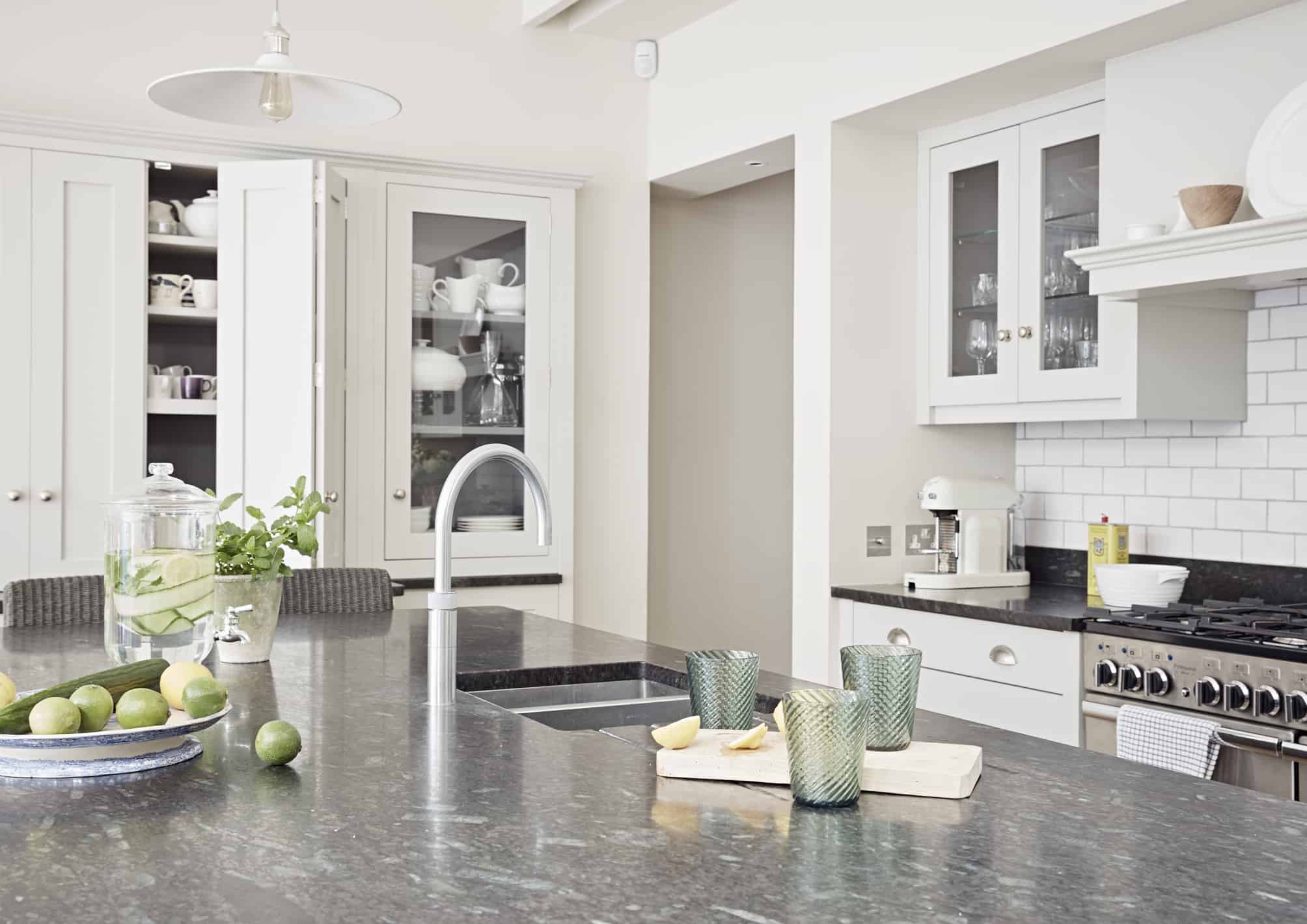 John Lewis of Hungerford luxury shaker style kitchen with dark granite worktops and white kitchen cabinetry with a kitchen island