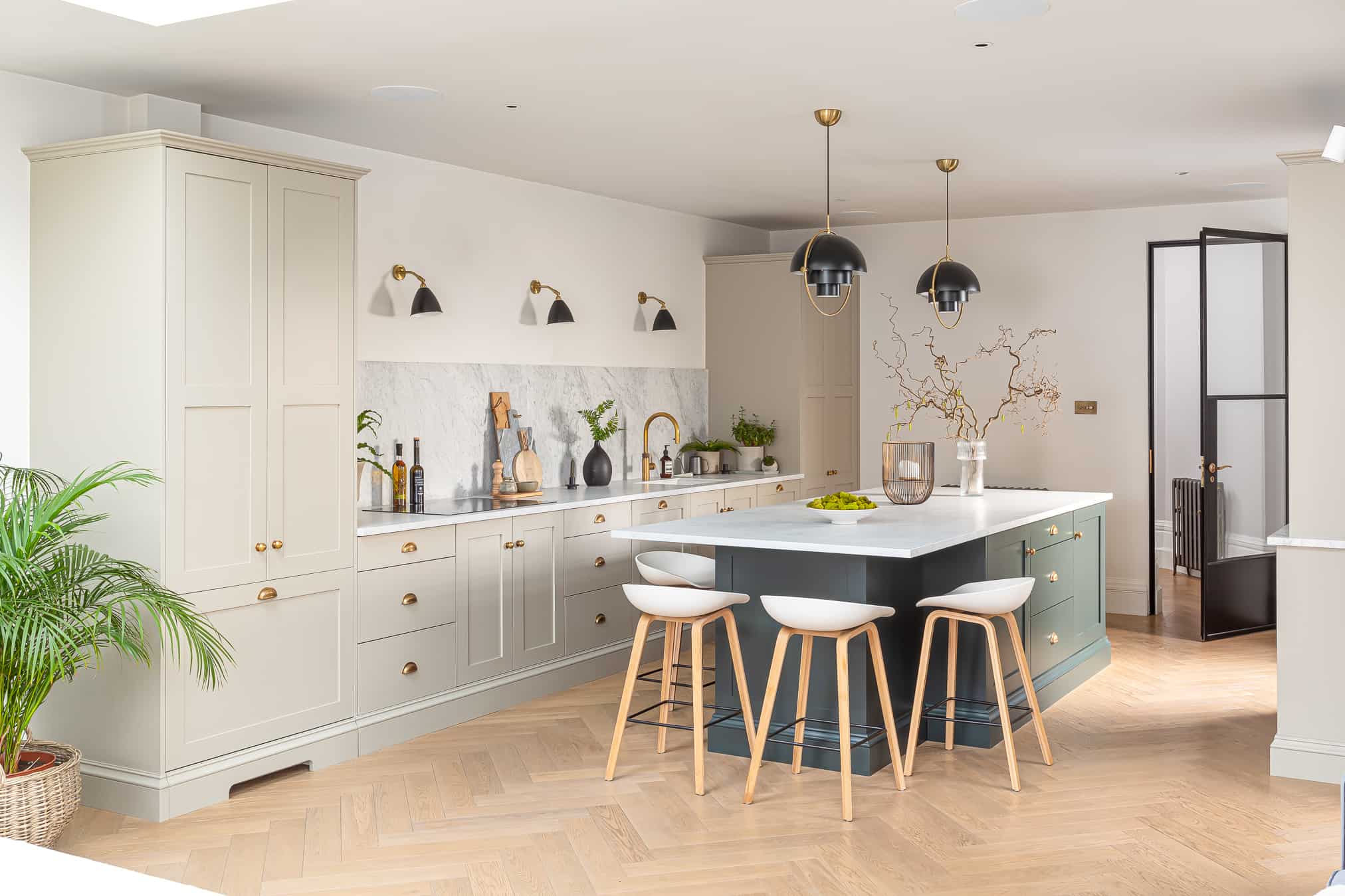 John Lewis of Hungerford luxury Shaker kitchen with green island and parquet chevron flooring with grey cabinetry